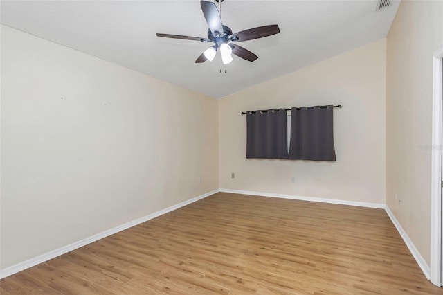 unfurnished room with vaulted ceiling, visible vents, a ceiling fan, baseboards, and light wood-style flooring