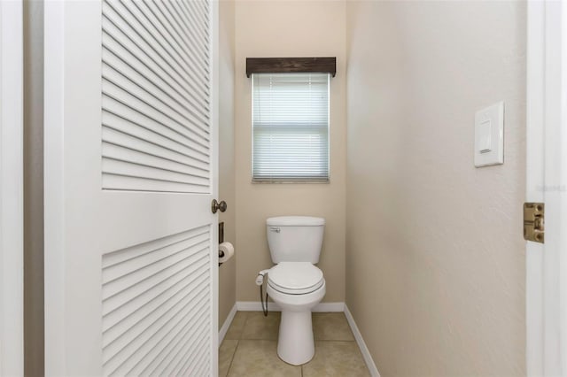 bathroom featuring tile patterned floors, baseboards, and toilet