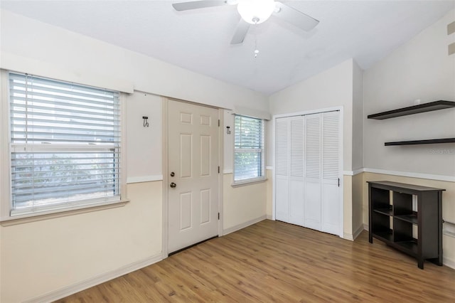 foyer featuring lofted ceiling, light wood finished floors, baseboards, and ceiling fan