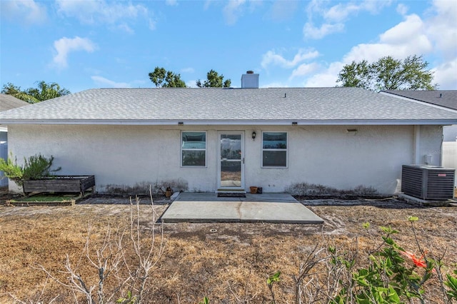 back of property with cooling unit, a patio area, roof with shingles, and stucco siding