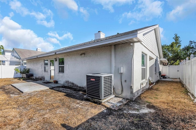 back of house featuring a fenced backyard, a patio area, cooling unit, and stucco siding