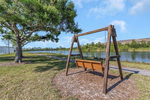 view of jungle gym featuring a lawn and a water view