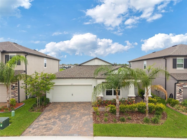 5059 Bromeliad Ave, Wimauma, FL 33598 - view of front facade with decorative driveway, a garage, stucco siding, and a front yard