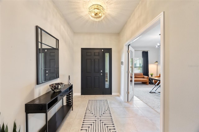 5059 Bromeliad Ave, Wimauma, FL 33598 - entryway with a chandelier, light tile patterned floors, and baseboards