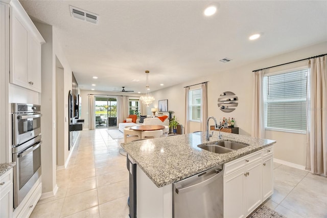 5059 Bromeliad Ave, Wimauma, FL 33598 - kitchen with stainless steel appliances, a sink, light tile patterned flooring, an island with sink, and open floor plan