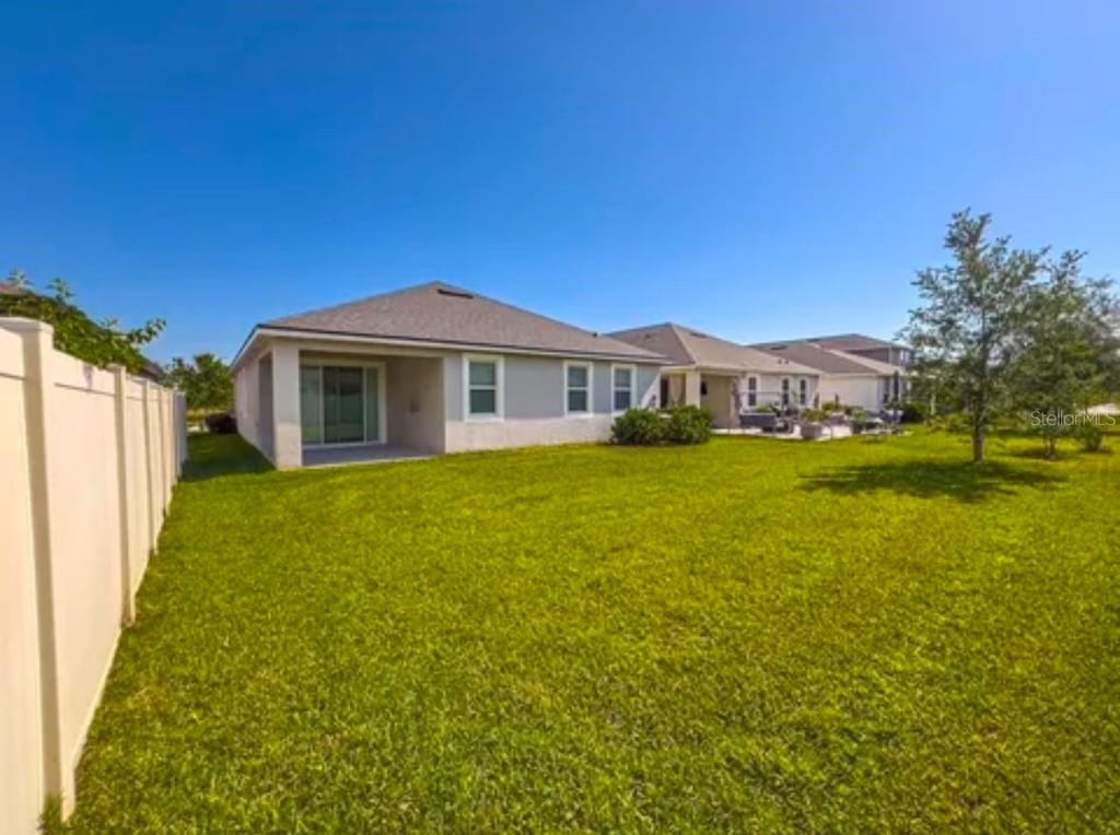 10729 Planer Picket Dr, Riverview, FL 33569 - back of house with fence, a yard, and stucco siding