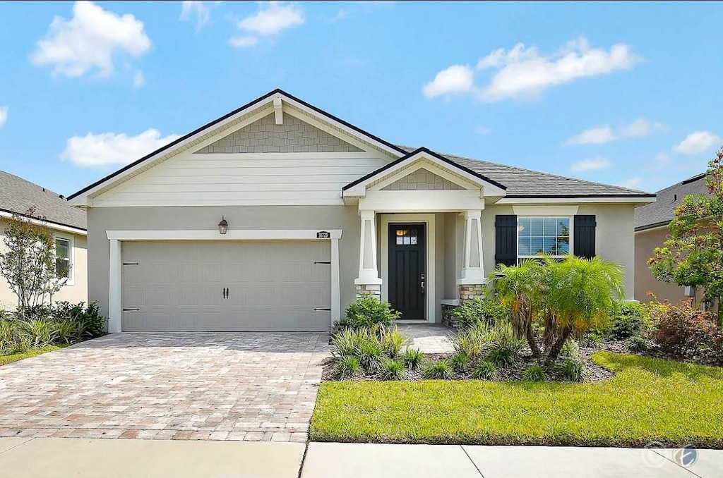 10729 Planer Picket Dr, Riverview, FL 33569 - view of front of property with a garage, stucco siding, and decorative driveway