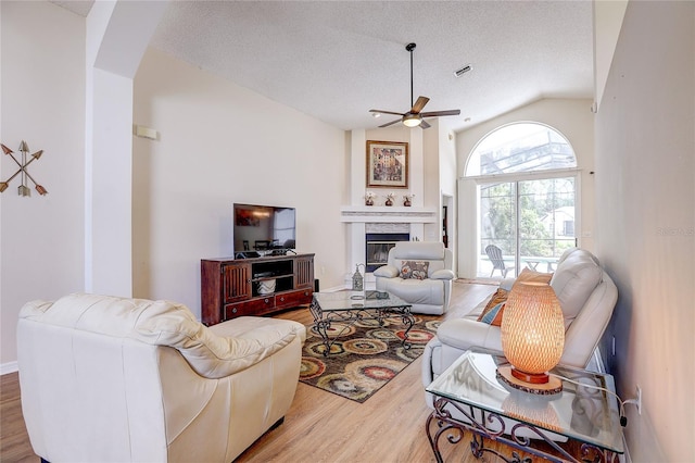 6410 Beaver Way, Tampa, FL 33625 - living area with ceiling fan, visible vents, wood finished floors, lofted ceiling, and a glass covered fireplace