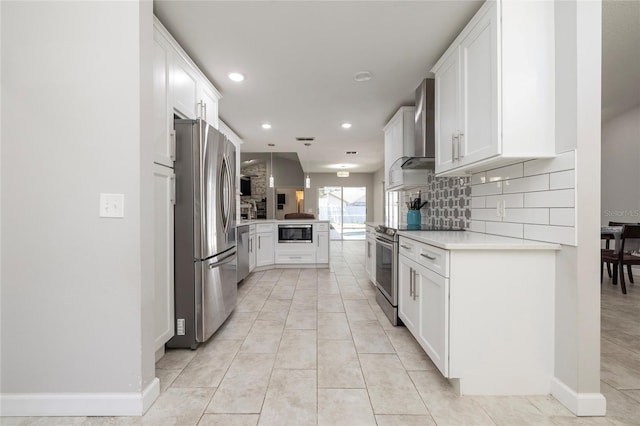 1916 Sandstone Pl, Clearwater, FL 33760 - kitchen featuring light countertops, wall chimney exhaust hood, white cabinets, tasteful backsplash, and appliances with stainless steel finishes