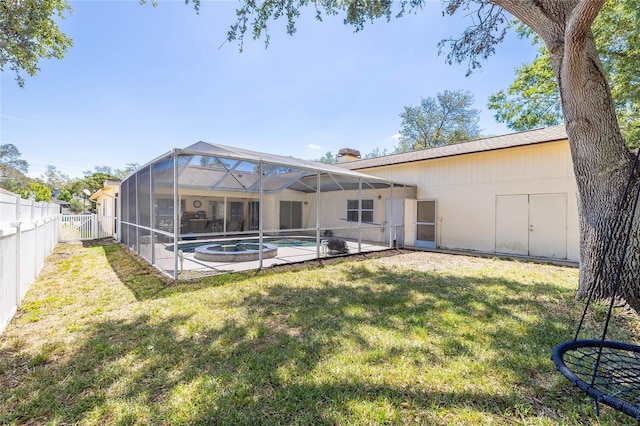 1916 Sandstone Pl, Clearwater, FL 33760 - back of house featuring an outdoor pool, a fenced backyard, a chimney, a lawn, and a patio