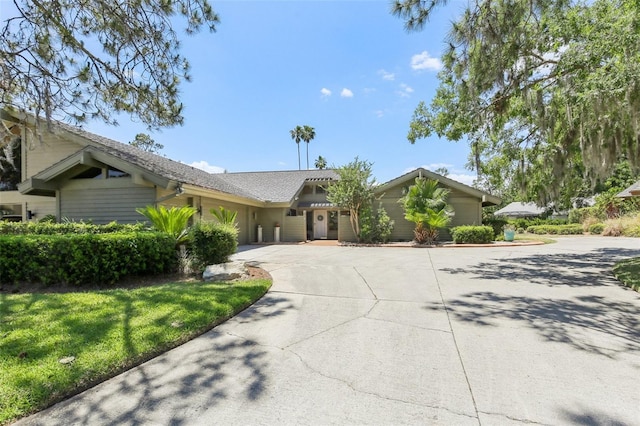 ranch-style home featuring curved driveway and a garage