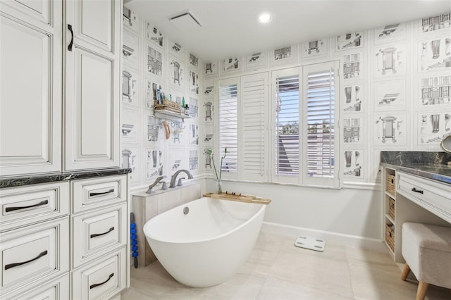 full bathroom featuring vanity, visible vents, recessed lighting, a freestanding bath, and baseboards