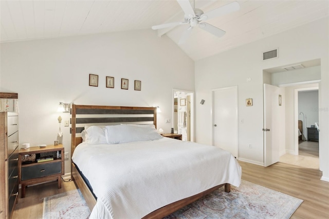 bedroom featuring baseboards, visible vents, high vaulted ceiling, wood finished floors, and beam ceiling