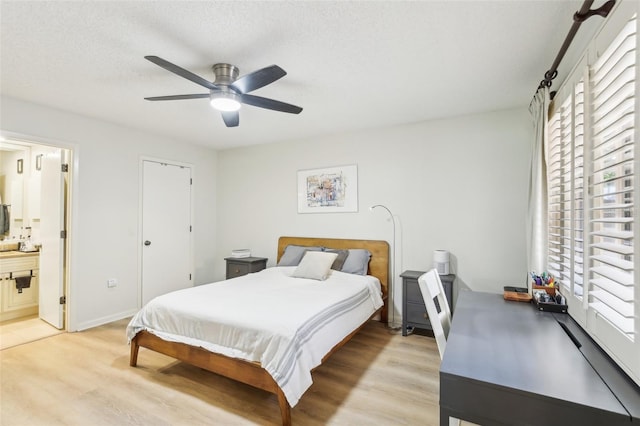 bedroom featuring multiple windows, ensuite bathroom, and light wood-style flooring