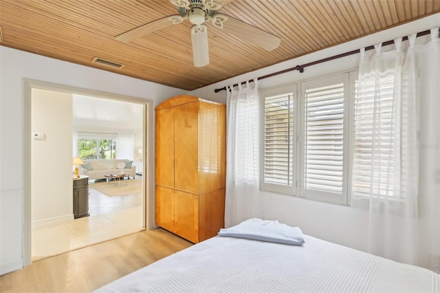 bedroom featuring a ceiling fan, light wood finished floors, visible vents, and wood ceiling