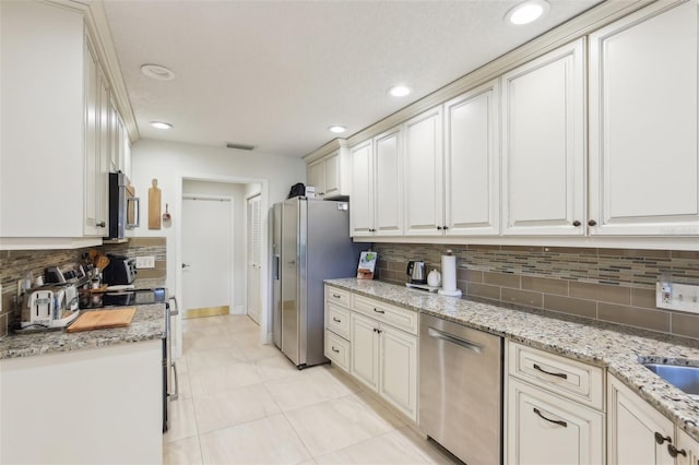 kitchen featuring stainless steel appliances, recessed lighting, decorative backsplash, light stone countertops, and baseboards