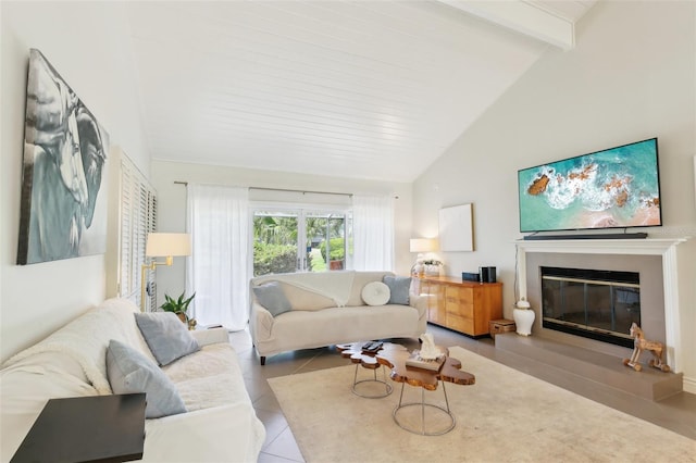 living room with beam ceiling, high vaulted ceiling, tile patterned flooring, and a glass covered fireplace