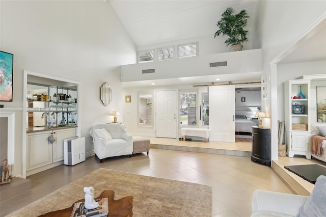 living room featuring tile patterned flooring, high vaulted ceiling, and visible vents