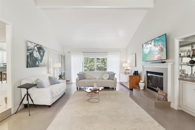 tiled living area with beamed ceiling, a glass covered fireplace, and high vaulted ceiling