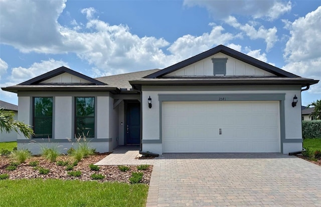 2541 Charter Oak Dr, North Port, FL 34289 - single story home with decorative driveway, board and batten siding, a garage, and stucco siding
