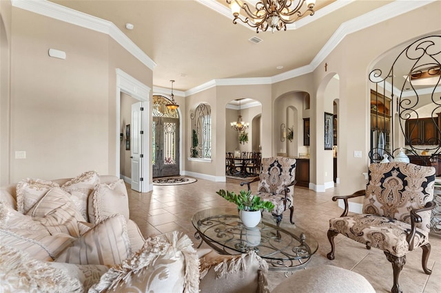 living room featuring crown molding, arched walkways, a chandelier, and baseboards