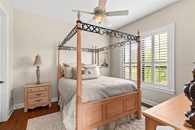 bedroom featuring baseboards, wood finished floors, ceiling fan, and multiple windows