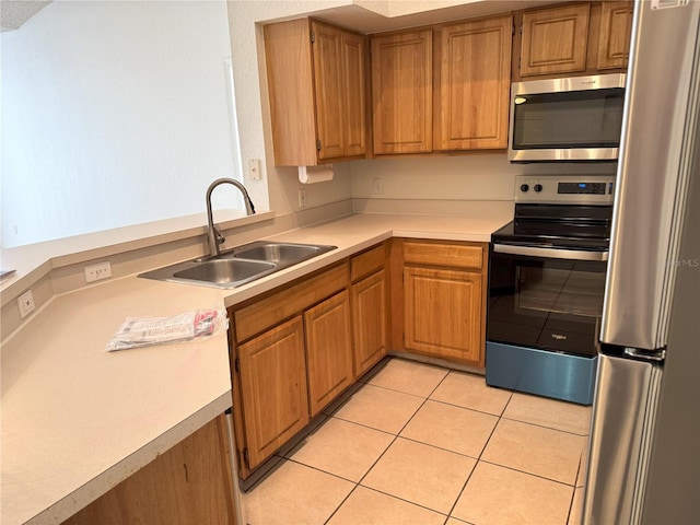 13103 Mulberry Park Dr Unit 833, Orlando, FL 32821 - kitchen featuring appliances with stainless steel finishes, light countertops, light tile patterned floors, brown cabinets, and a peninsula