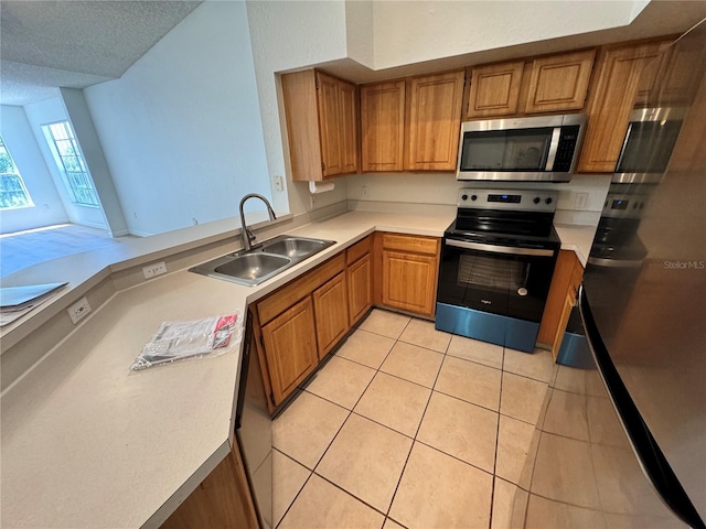 13103 Mulberry Park Dr Unit 833, Orlando, FL 32821 - kitchen featuring stainless steel appliances, brown cabinets, light tile patterned floors, light countertops, and a peninsula