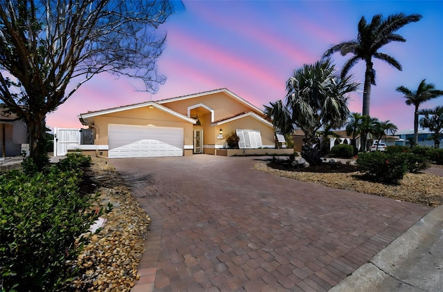 17 Bellevue Dr, Treasure Island, FL 33706 - single story home featuring decorative driveway, stucco siding, and a garage