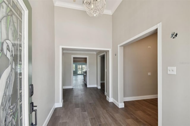 17 Bellevue Dr, Treasure Island, FL 33706 - foyer entrance featuring a chandelier, crown molding, baseboards, dark wood-type flooring, and a towering ceiling