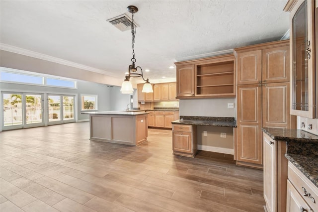 17 Bellevue Dr, Treasure Island, FL 33706 - kitchen with a center island with sink, ornamental molding, a sink, baseboards, and wood finished floors