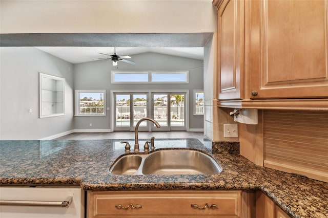 17 Bellevue Dr, Treasure Island, FL 33706 - kitchen featuring a sink, ceiling fan, vaulted ceiling, dark stone counters, and baseboards
