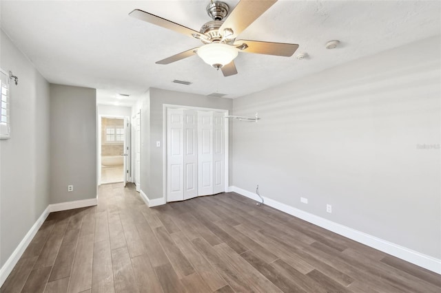 17 Bellevue Dr, Treasure Island, FL 33706 - unfurnished bedroom with dark wood-style flooring, baseboards, a closet, and a ceiling fan