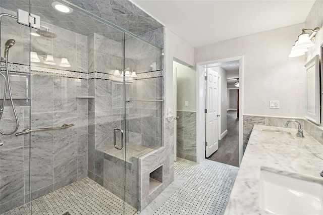 17 Bellevue Dr, Treasure Island, FL 33706 - full bathroom featuring double vanity, a stall shower, and tile walls