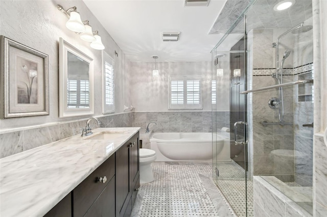 17 Bellevue Dr, Treasure Island, FL 33706 - full bathroom with toilet, vanity, a garden tub, a shower stall, and tile walls