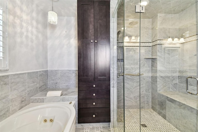 17 Bellevue Dr, Treasure Island, FL 33706 - full bathroom featuring a jetted tub, a stall shower, and tile walls