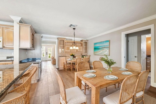 17 Bellevue Dr, Treasure Island, FL 33706 - dining area with light wood-style floors, a chandelier, and ornamental molding