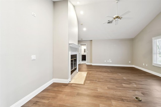 17 Bellevue Dr, Treasure Island, FL 33706 - unfurnished living room with a ceiling fan, high vaulted ceiling, baseboards, light wood-style flooring, and a premium fireplace