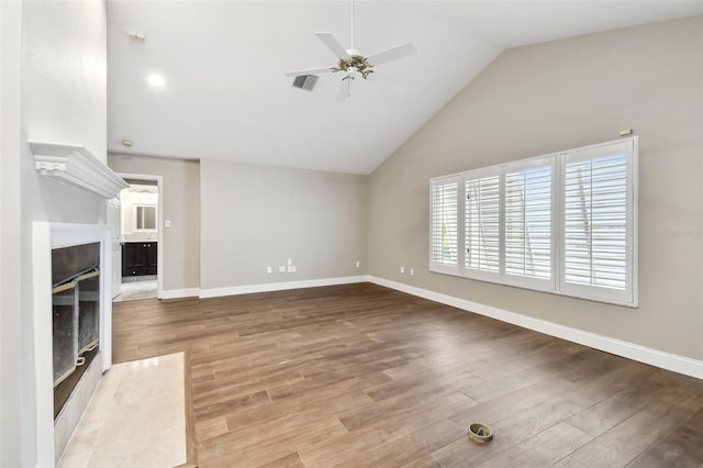 17 Bellevue Dr, Treasure Island, FL 33706 - unfurnished living room with ceiling fan, lofted ceiling, wood finished floors, baseboards, and a fireplace