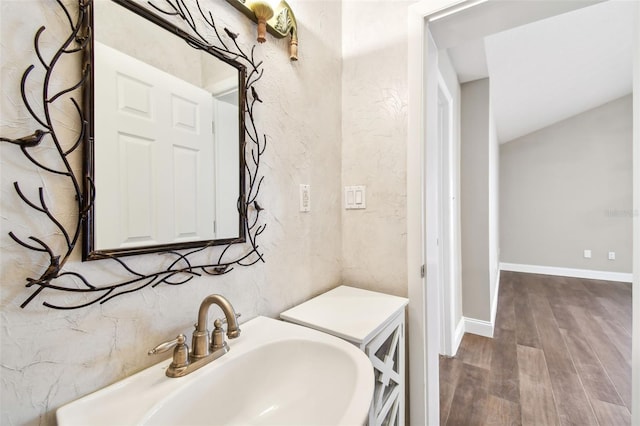 17 Bellevue Dr, Treasure Island, FL 33706 - bathroom featuring a sink, wood finished floors, and baseboards