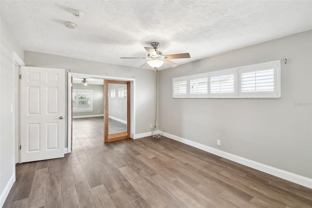 17 Bellevue Dr, Treasure Island, FL 33706 - unfurnished room with a ceiling fan, baseboards, healthy amount of natural light, wood finished floors, and a textured ceiling