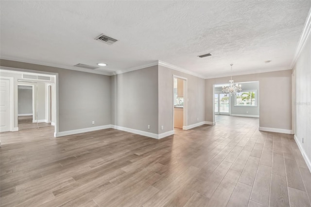 17 Bellevue Dr, Treasure Island, FL 33706 - empty room featuring a chandelier, light wood-style flooring, baseboards, a textured ceiling, and crown molding