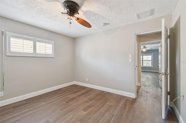 17 Bellevue Dr, Treasure Island, FL 33706 - empty room with ceiling fan, wood finished floors, baseboards, and a textured ceiling