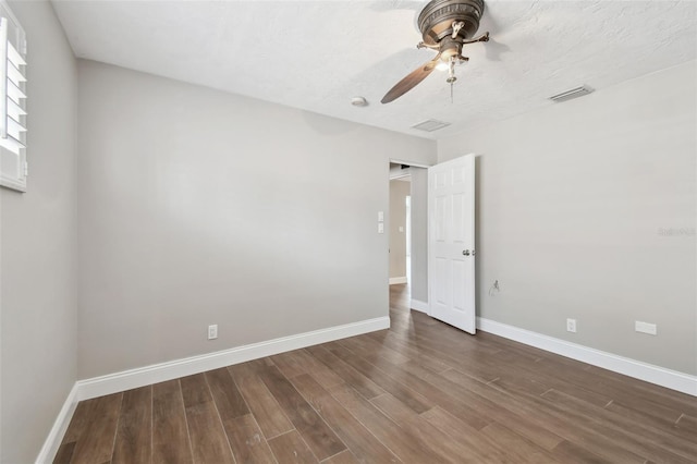 17 Bellevue Dr, Treasure Island, FL 33706 - spare room with dark wood-type flooring, baseboards, and ceiling fan