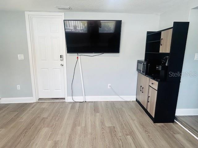 6401 30th Way N, Saint Petersburg, FL 33702 - unfurnished living room featuring baseboards and light wood-type flooring