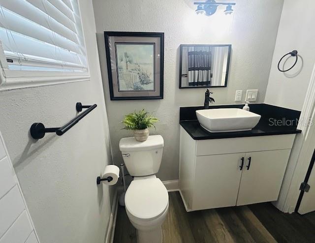 6401 30th Way N, Saint Petersburg, FL 33702 - half bathroom featuring toilet, vanity, and wood finished floors