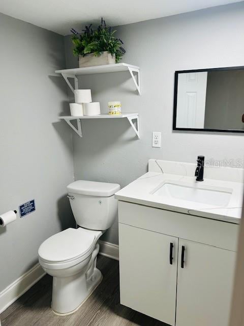 6401 30th Way N, Saint Petersburg, FL 33702 - bathroom with baseboards, toilet, vanity, and wood finished floors