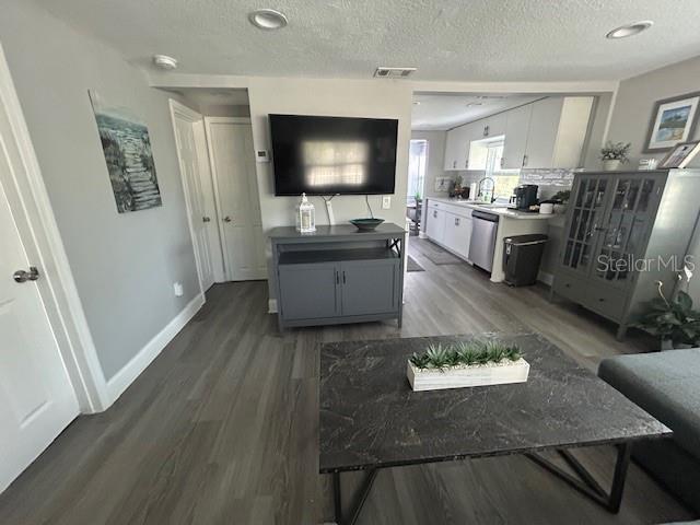6401 30th Way N, Saint Petersburg, FL 33702 - kitchen with stainless steel dishwasher, wood finished floors, a textured ceiling, and visible vents