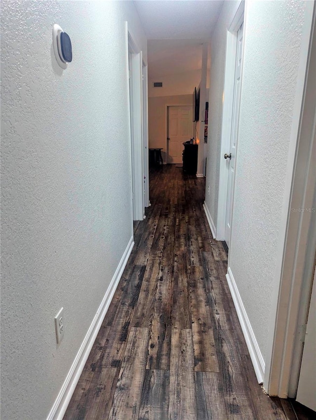 37654 Eiland Blvd, Zephyrhills, FL 33542 - hallway featuring a textured wall, dark wood finished floors, and baseboards