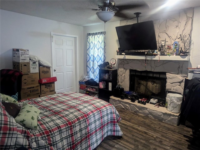 37654 Eiland Blvd, Zephyrhills, FL 33542 - bedroom with wood finished floors, ceiling fan, and a stone fireplace